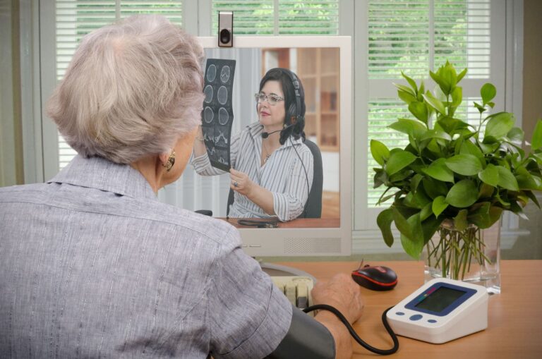 Telehealth kiosk - retired woman communicating with doctor through telehealth kiosk