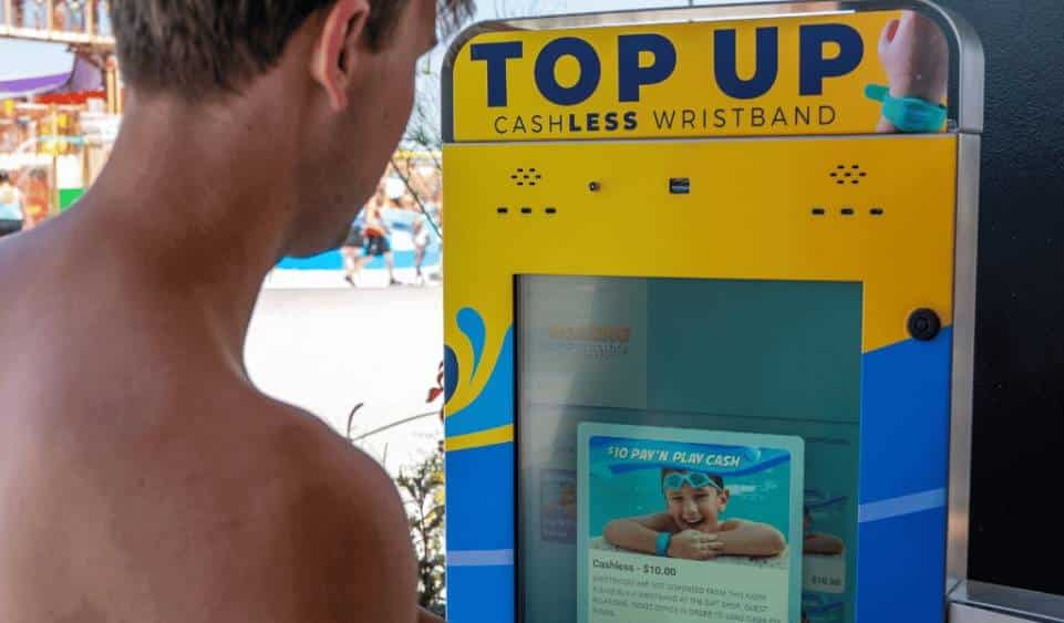 A man trying to top up using a kiosk and a cashless wristband